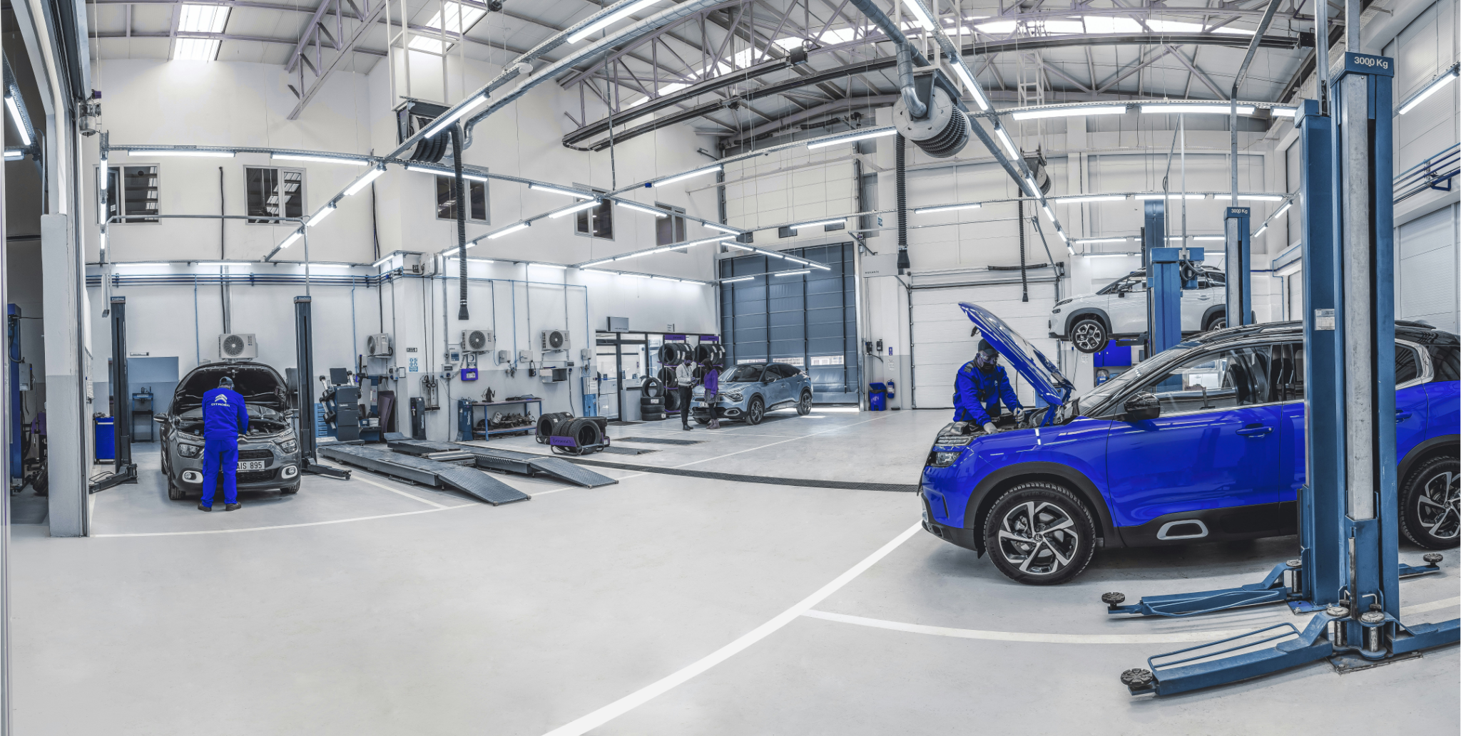 Werkstatt mit mehreren Fahrzeugen in einer großen Halle